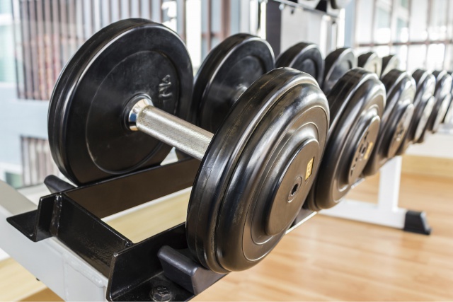 Many black dumbbell lined up in a fitness room.