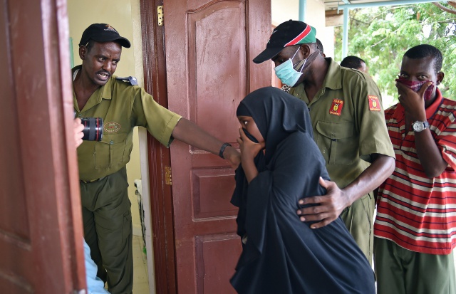 People cover their noses as they arrive to see the bodies of attackers - KENYA 2015
