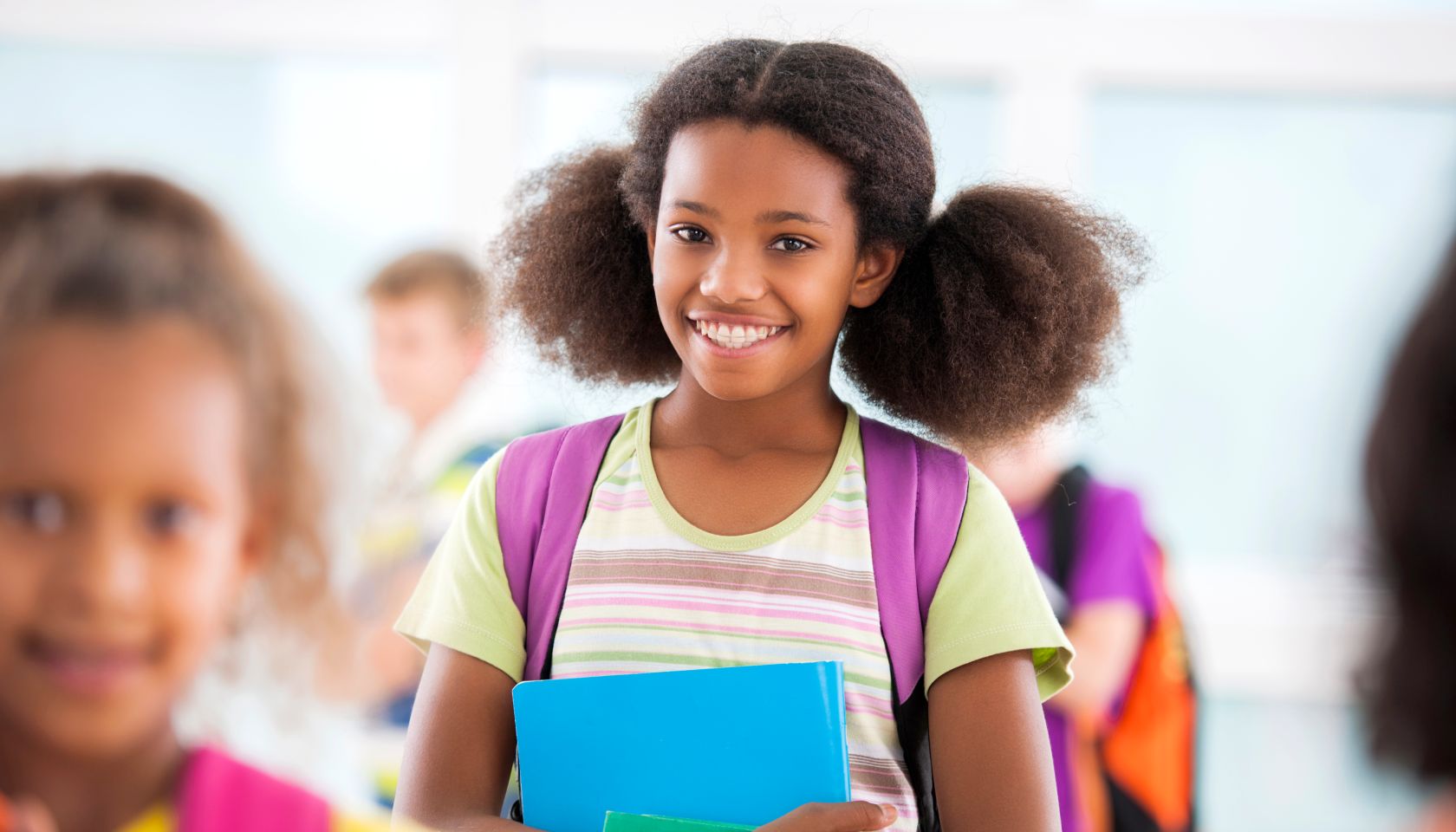 African American schoolgirl smiling and looking at camera.