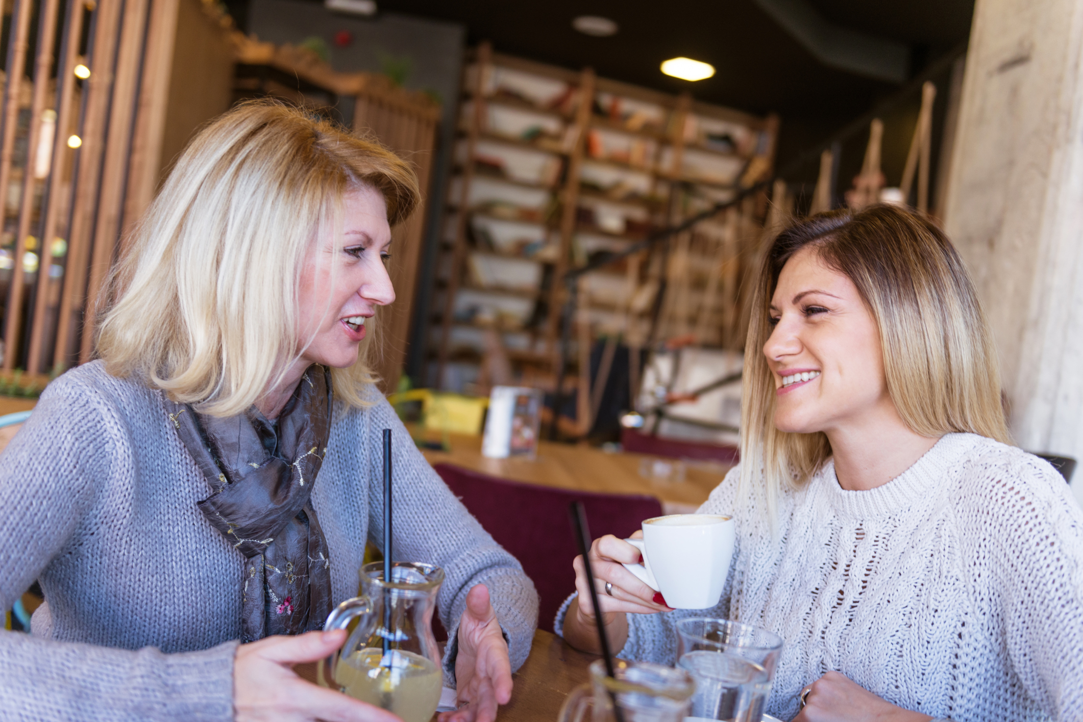 Mature and young woman having coffee time in modern cafe