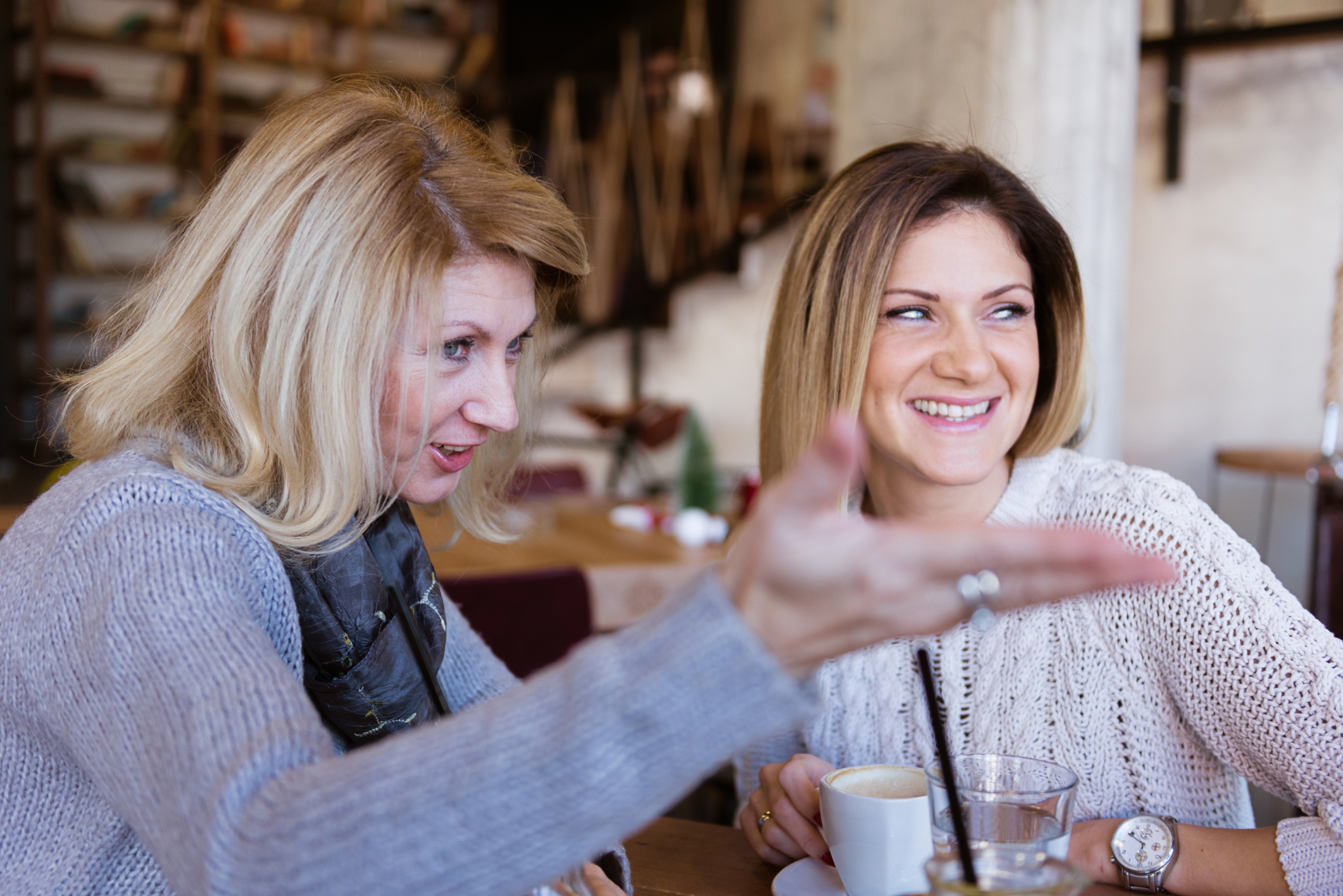 Mature and young woman having coffee time in modern cafe