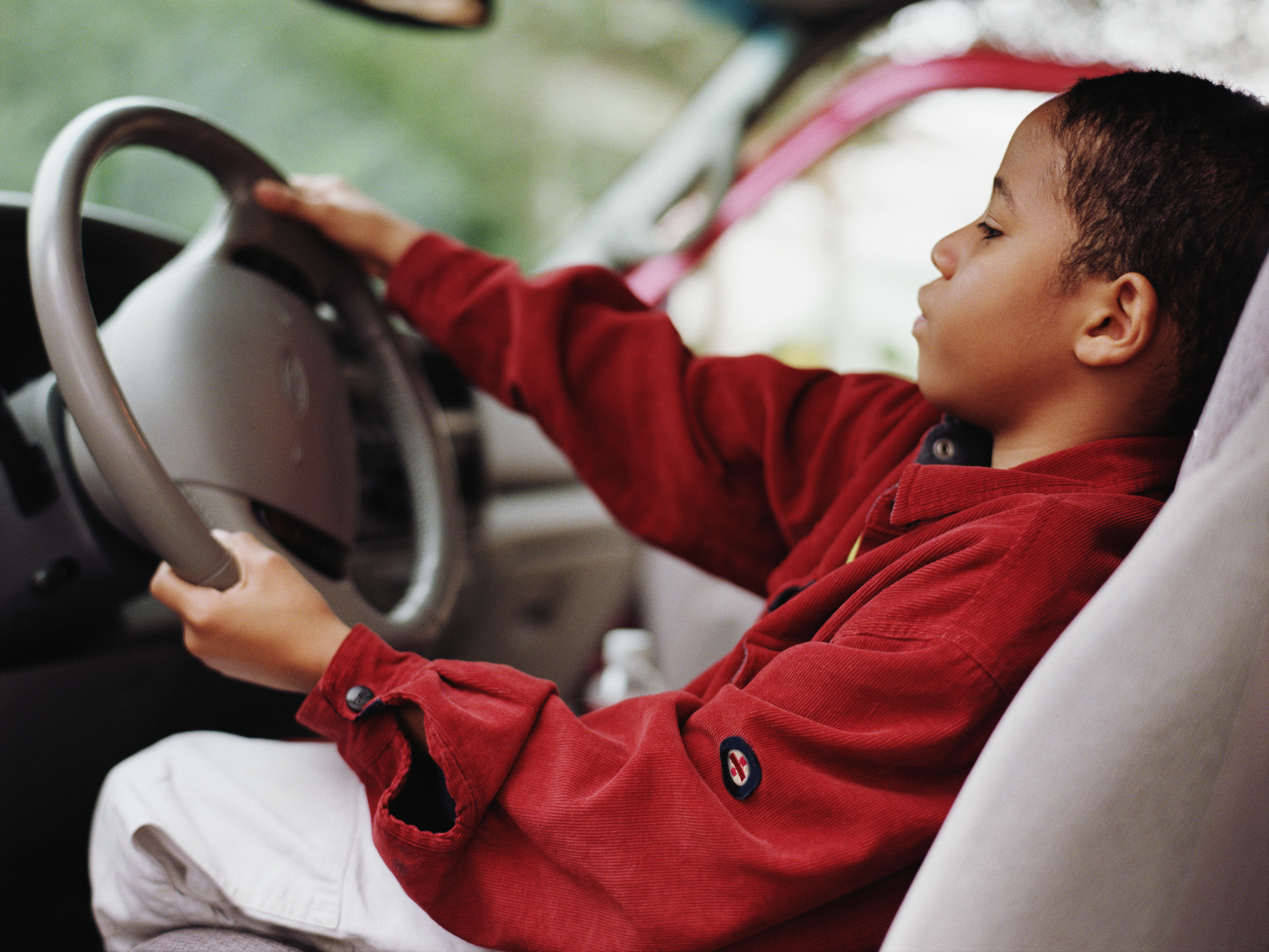 African boy pretending to drive car