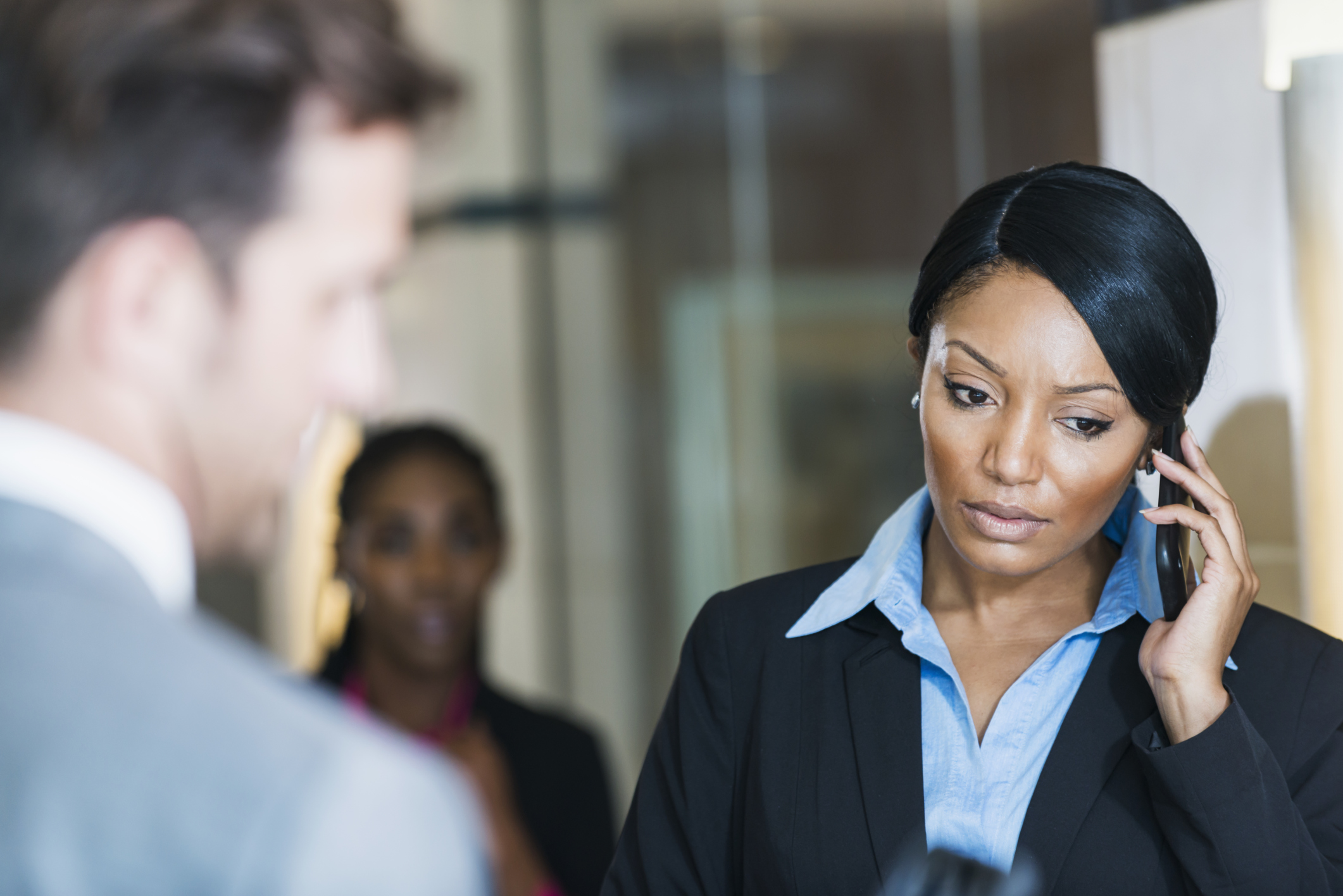 Serious businesswoman talking on mobile phone in office