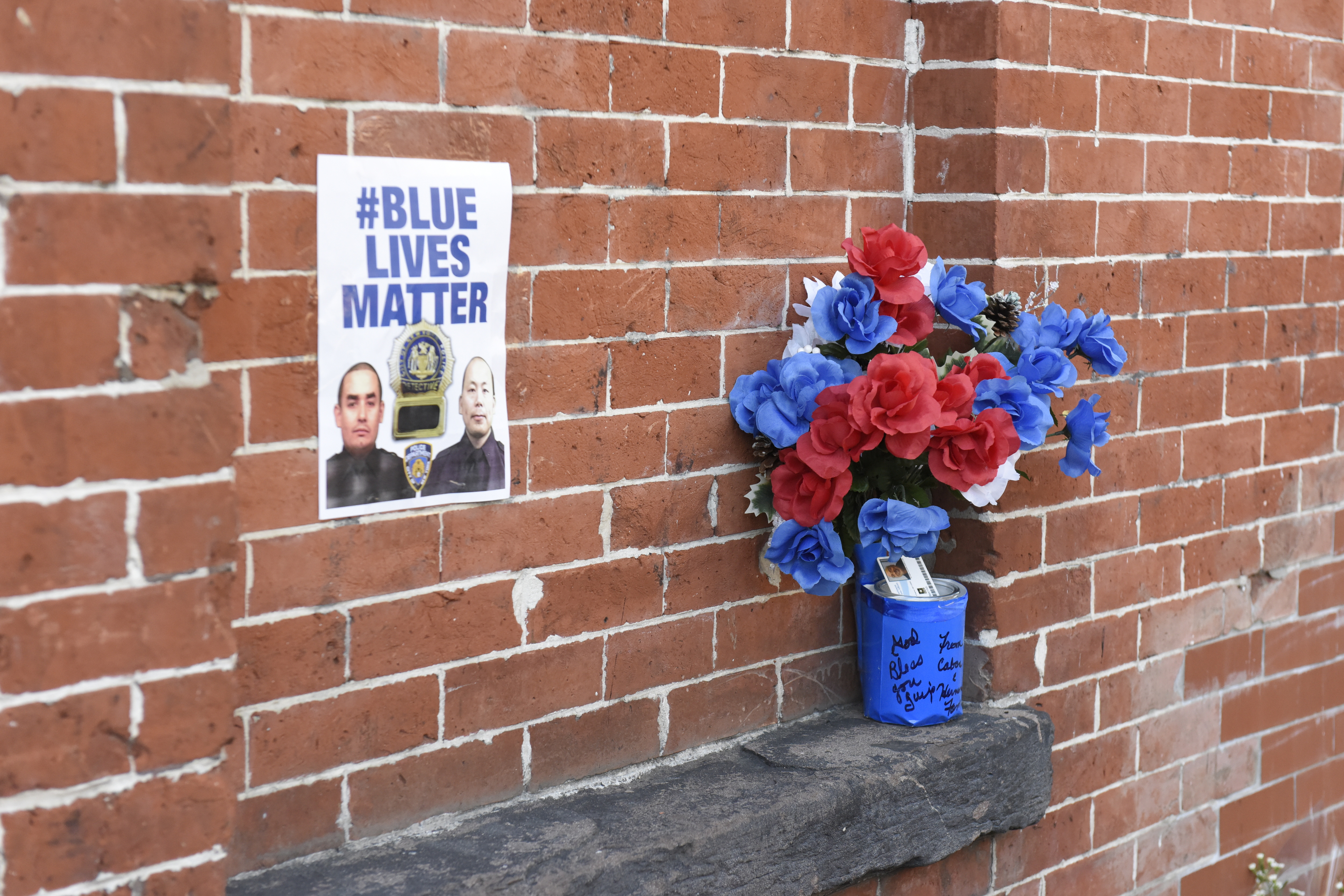 Blue Lives Matter poster on brick wall at site where...