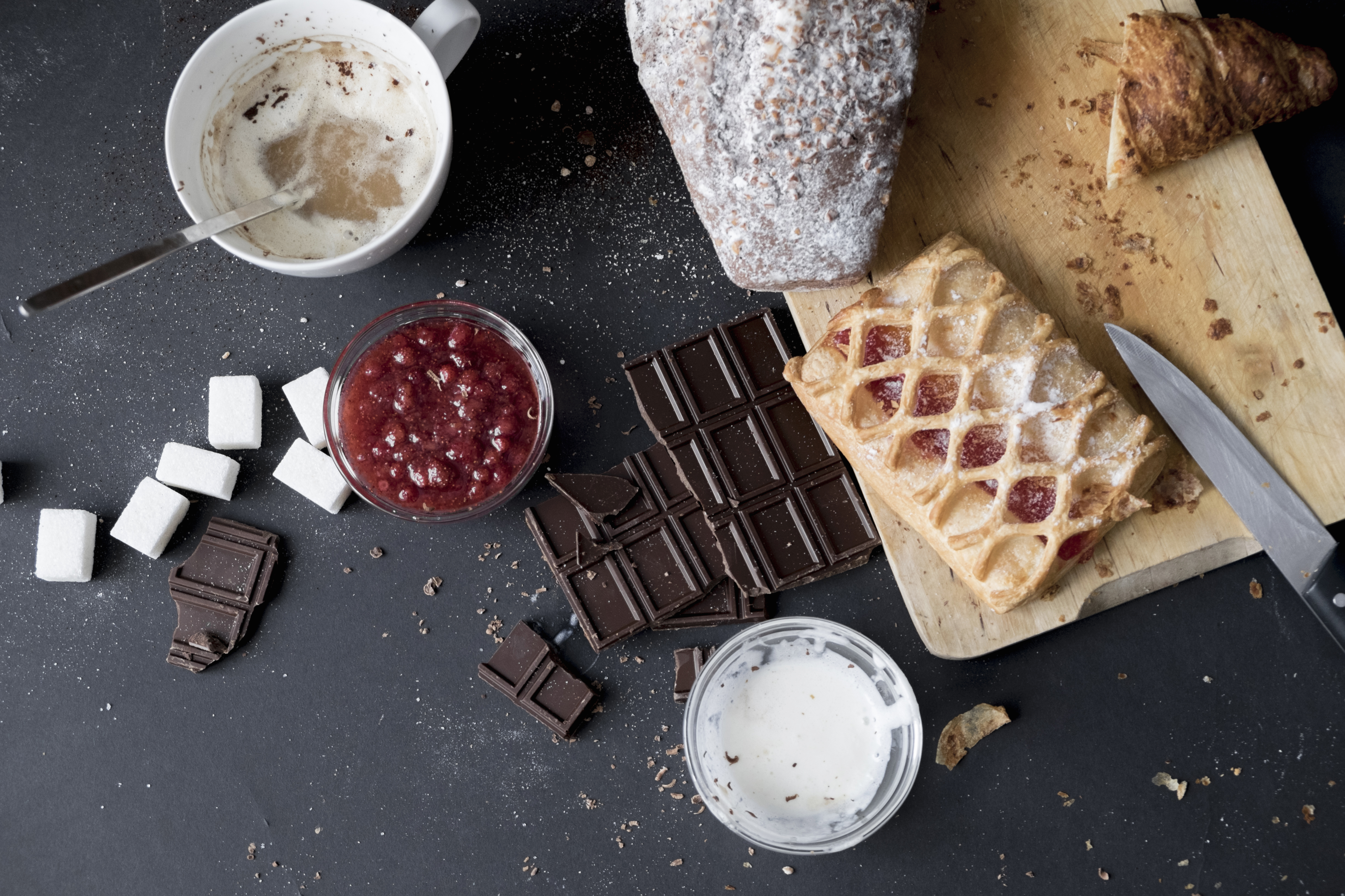 Overhead view of apple strudel, chocolate, cake and ingredients on kitchen table