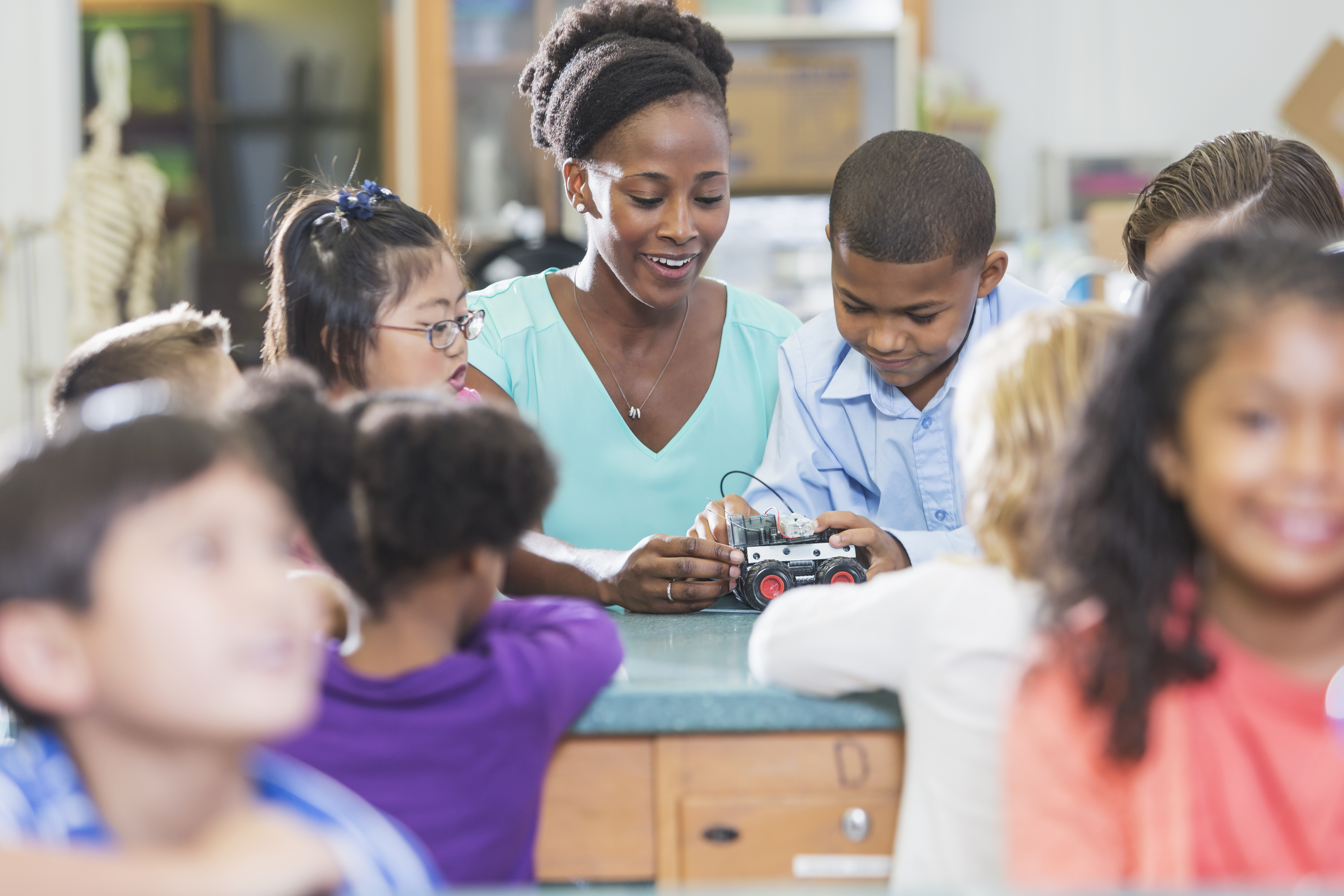 Multiracial teacher and children in science lab