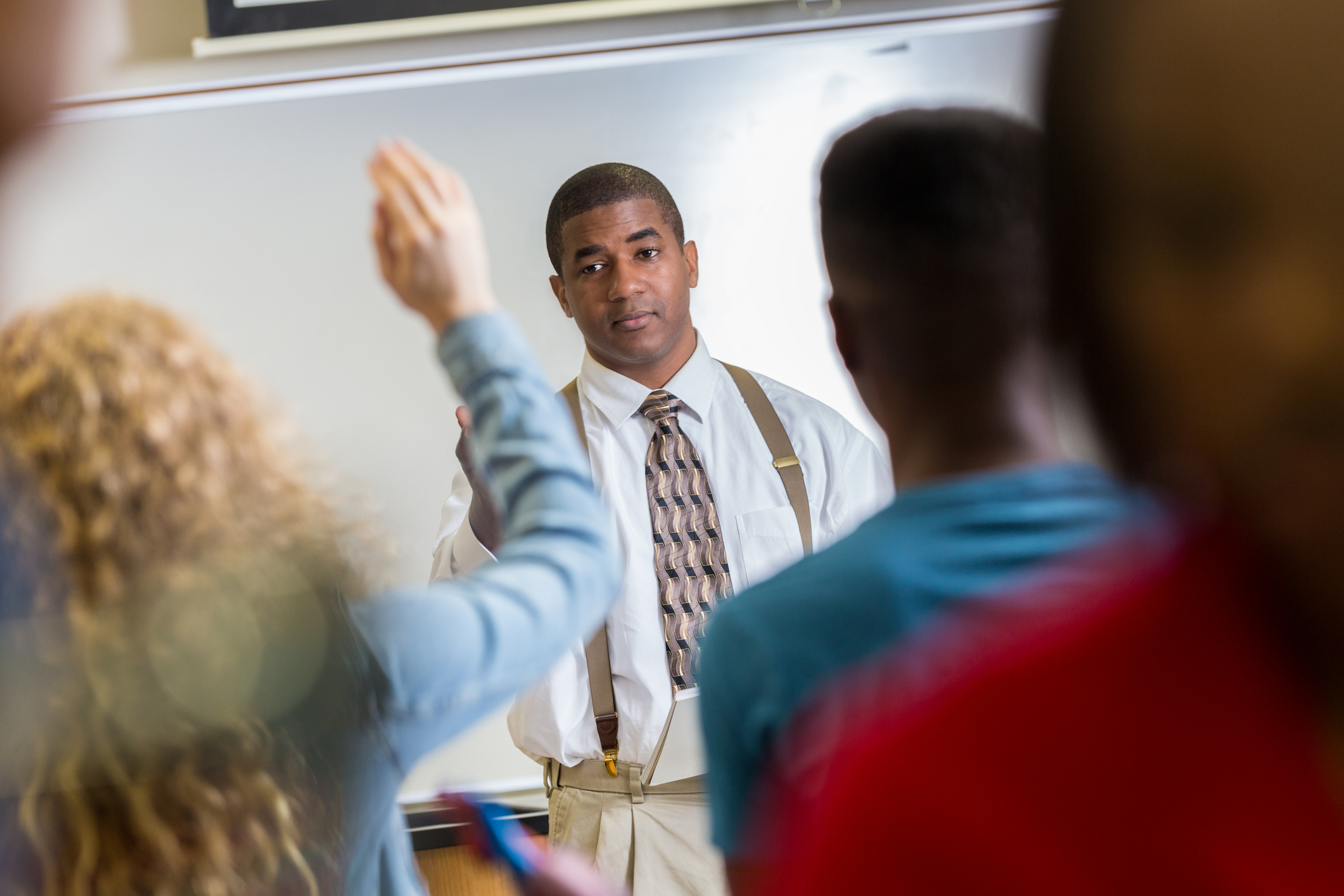 High school student raises hand in science class
