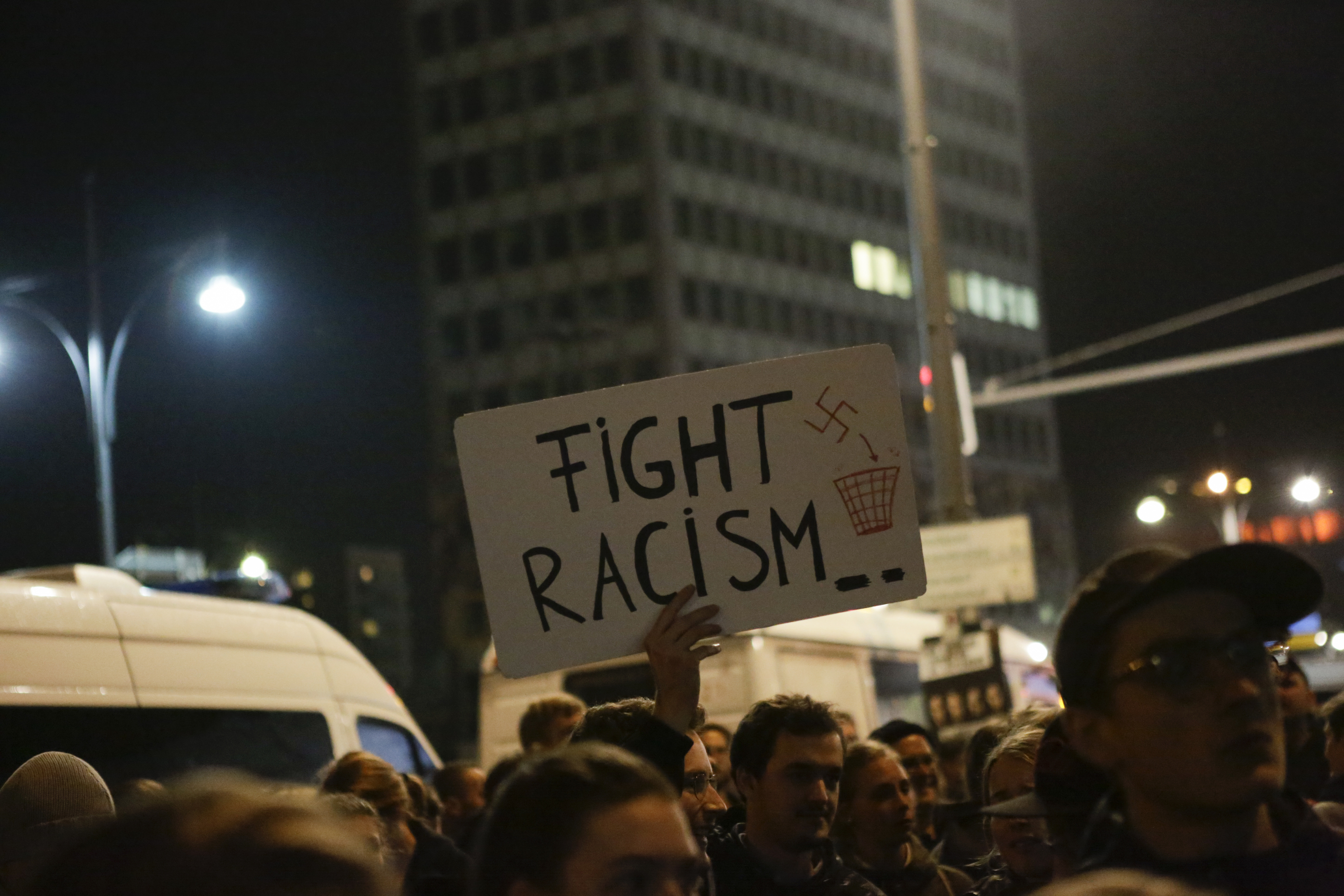 A protester holds up a sign that reads 'Fight racism'.
