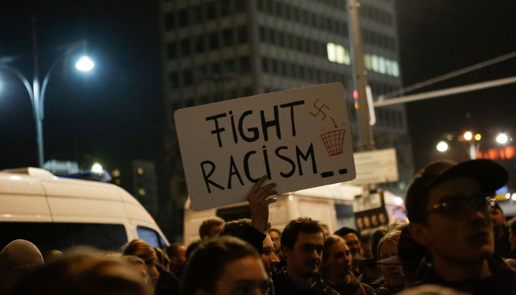 A protester holds up a sign that reads 'Fight racism'.