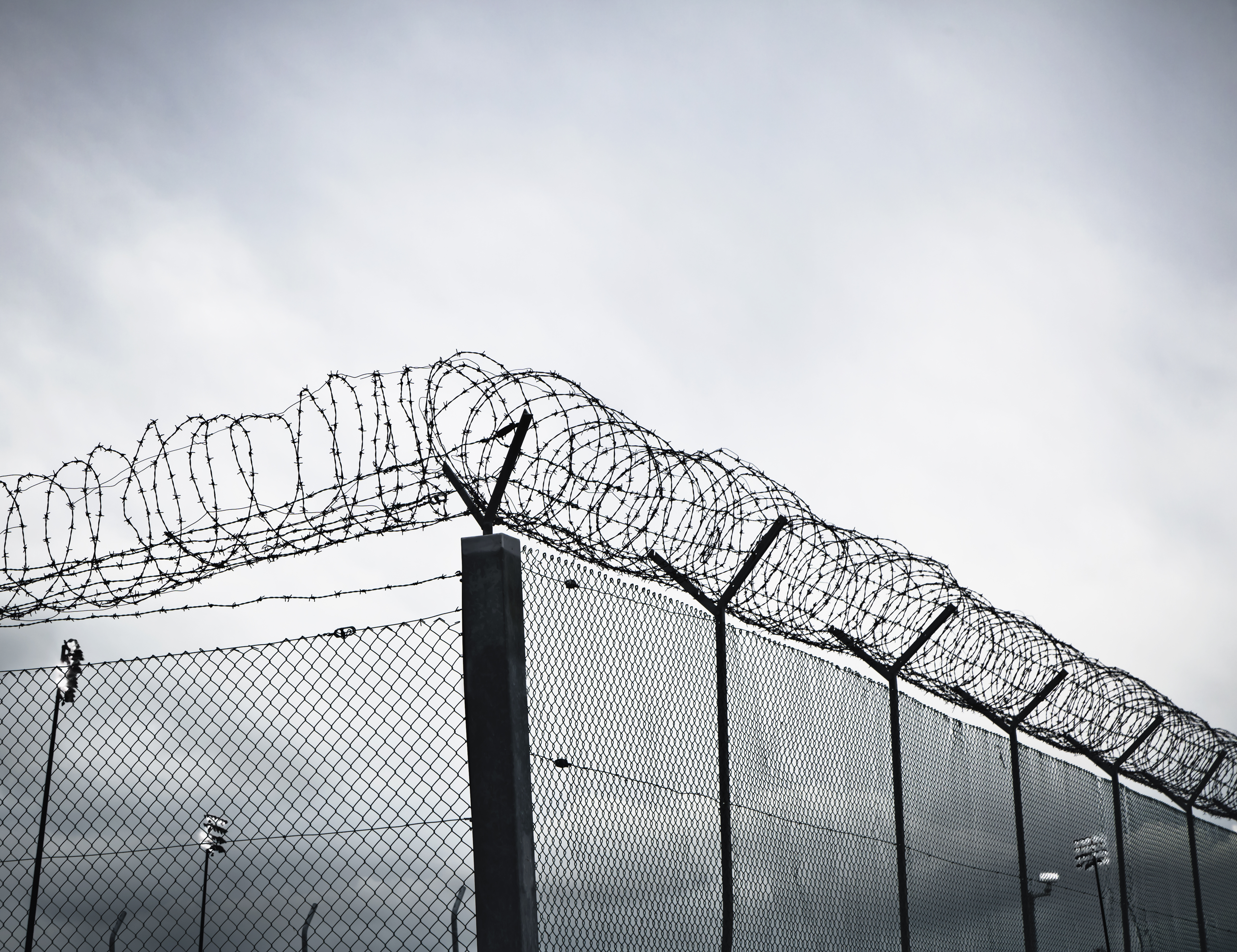 Chain link fence with barbed wire and razor wire.