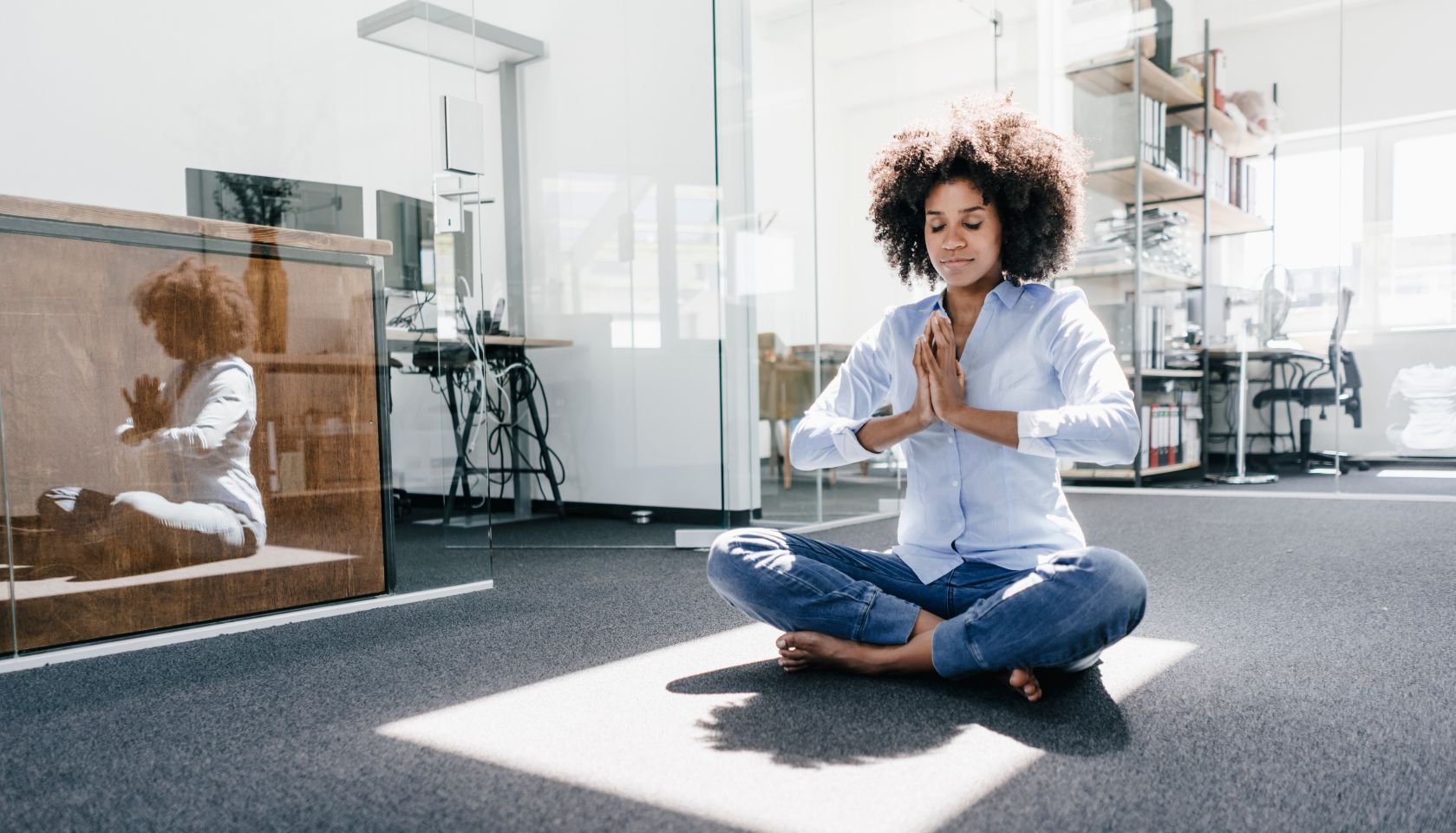 Young woman doing yoga in office