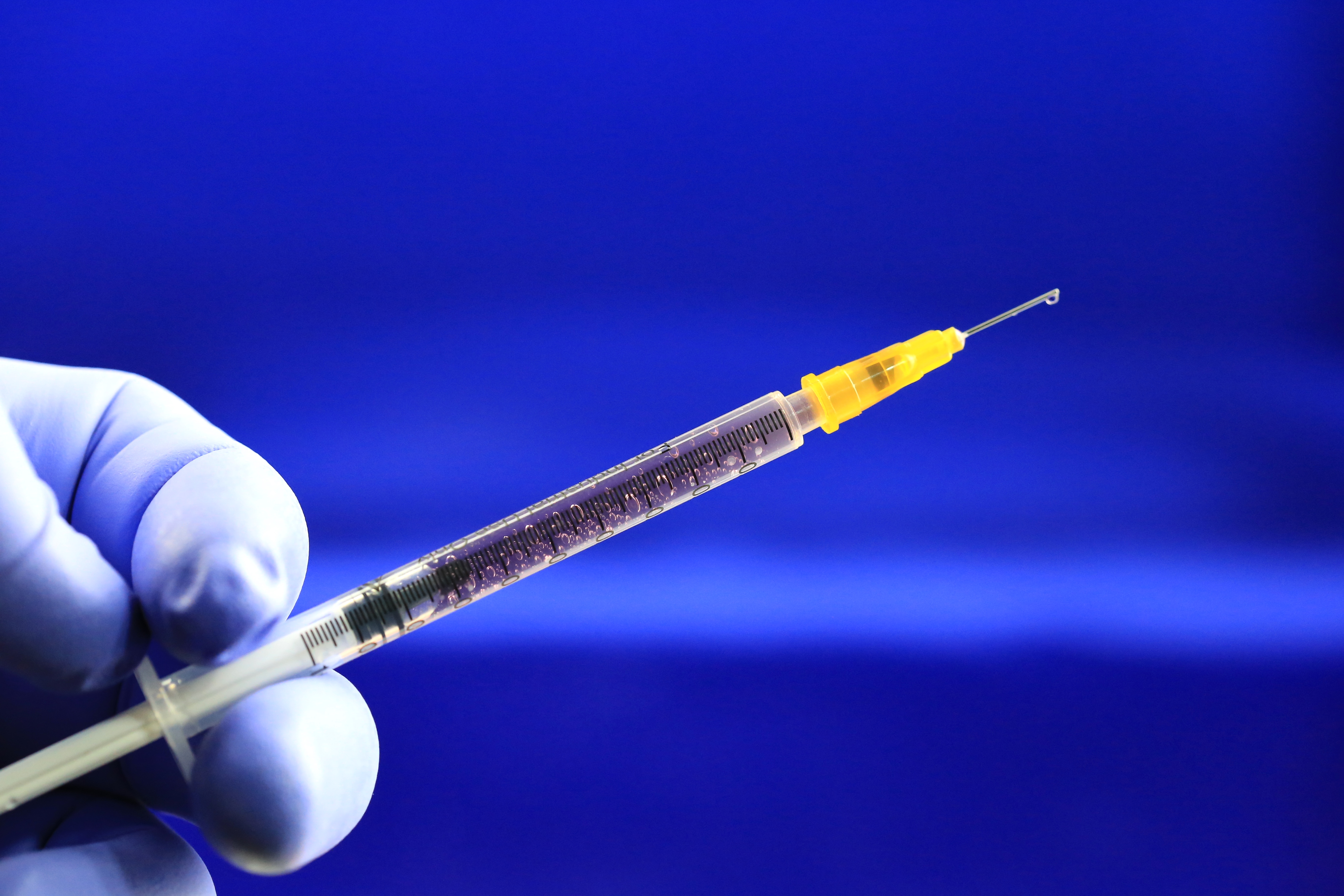 Health worker prepares a Hypodermic needle with Influenza vaccine