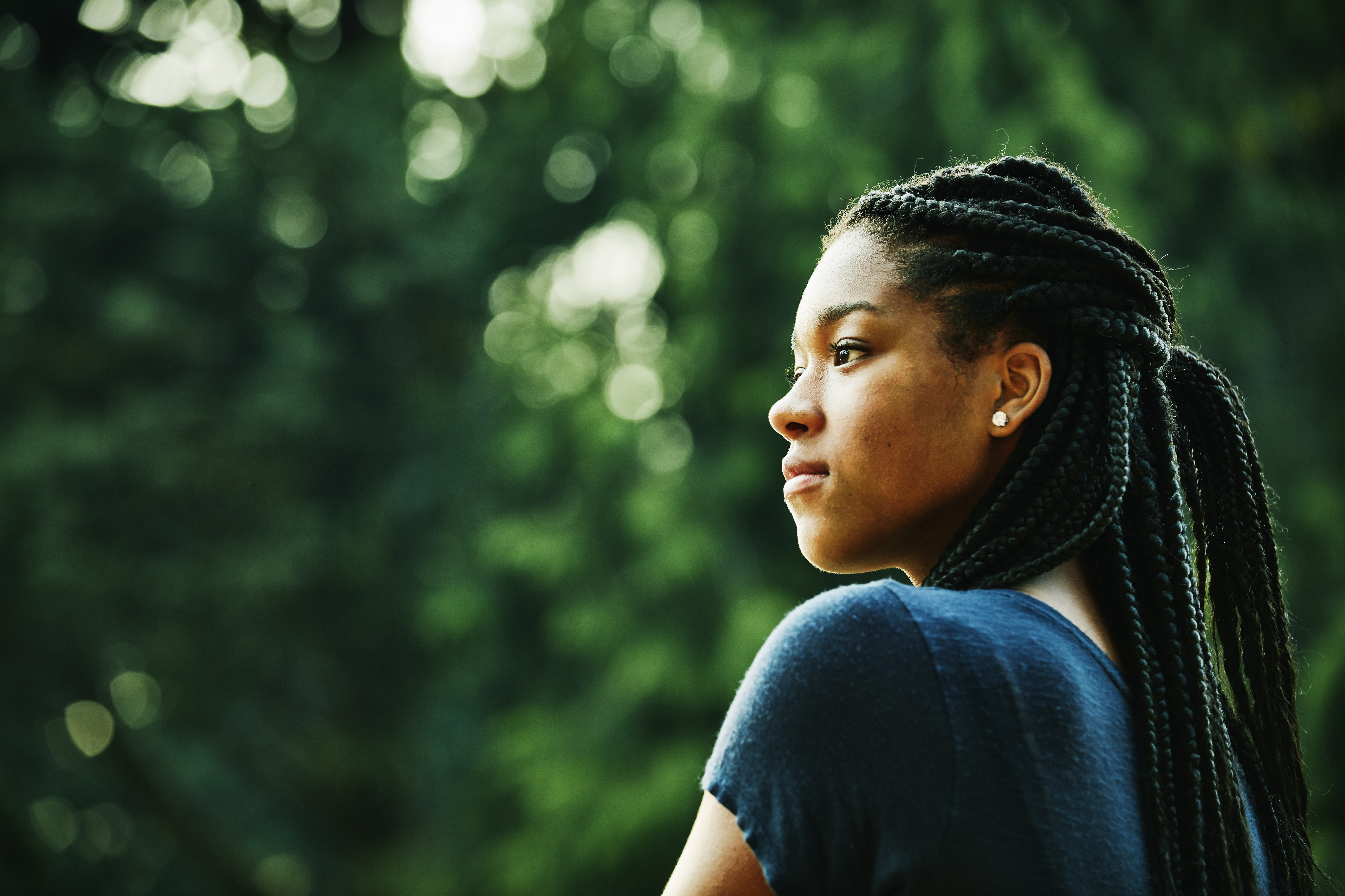 Portrait of young woman standing in front yard on summer evening
