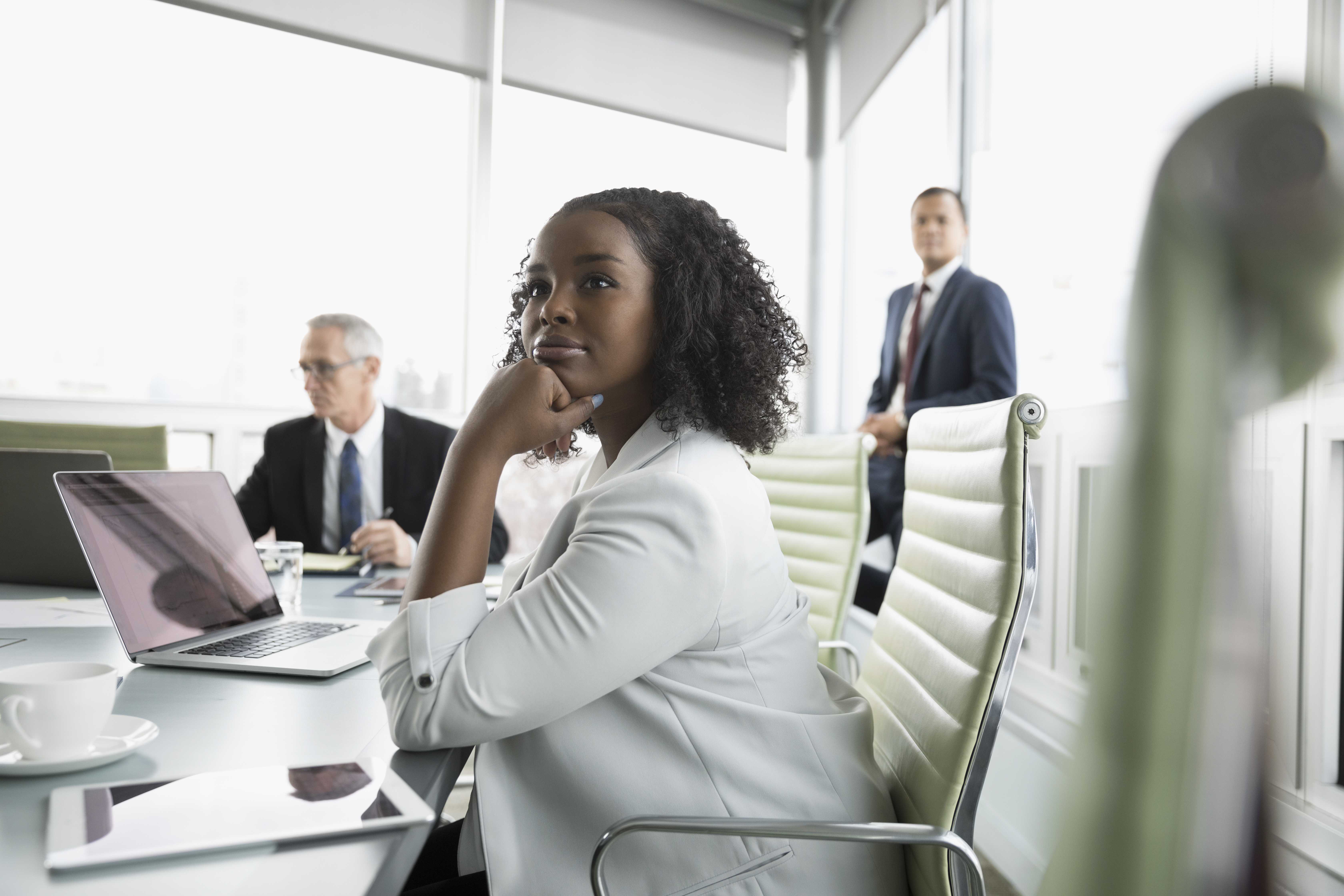 Confident, attentive businesswoman listening in conference room meeting