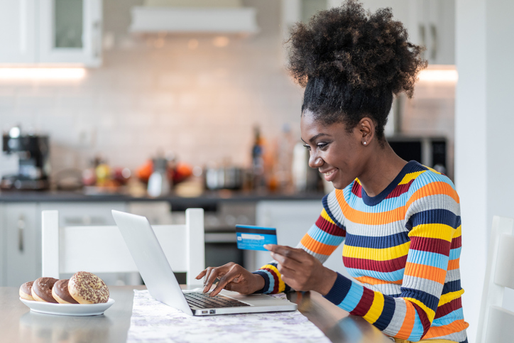 Smiling afro woman shopping online at home