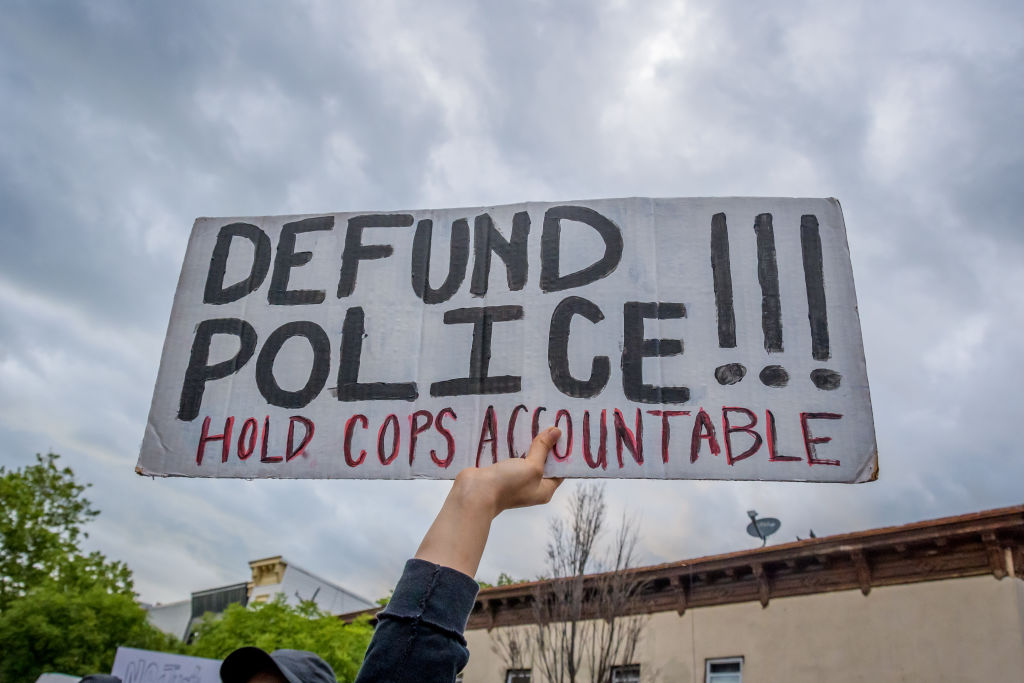 A participant holding a Defund Police sign at the protest.