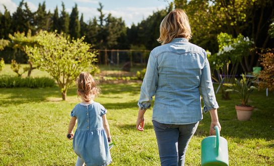 Mother and 4 Year Old Daughter Gardening in Family Backyard