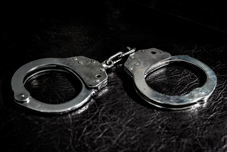 Metal handcuffs on the Leather sofa. criminal justice
