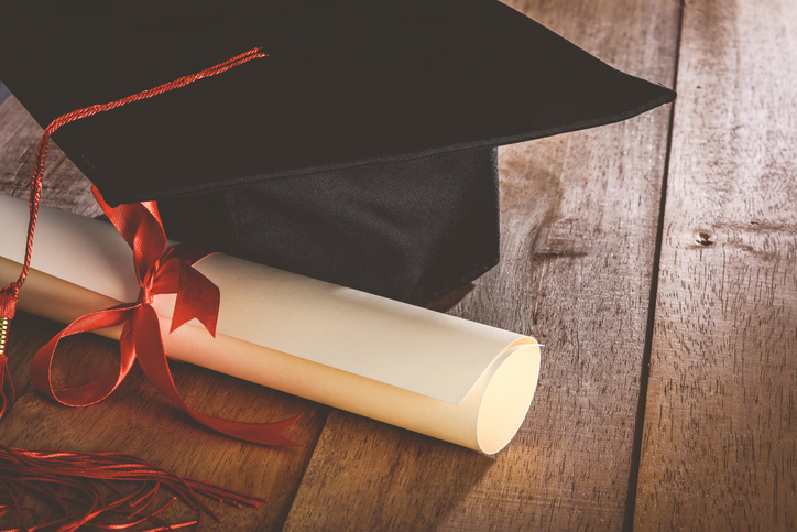 Close-Up Of Degree With Mortarboard On Table