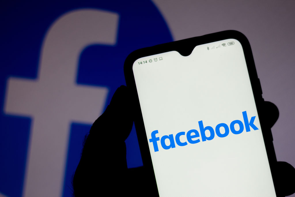 In this photo illustration a Facebook logo seen displayed on...