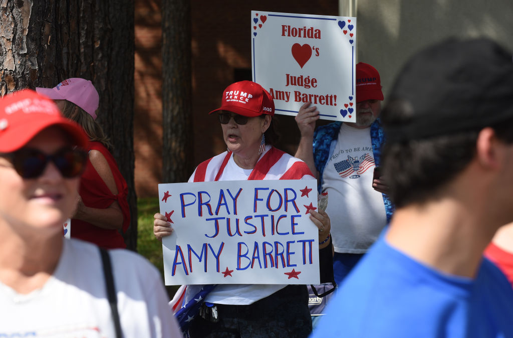 A woman holds a placard in support of Judge Amy Coney...