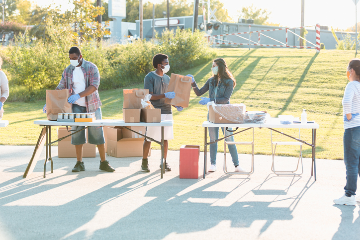 Diverse volunteers prepare bags of donated food