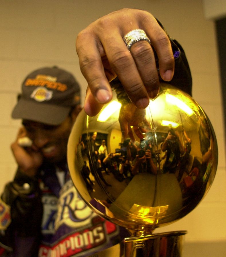 031395.SP.0615.lakers.21WS Lakers Kobe Bryant Bryant hangs on to the Championship trophy after de