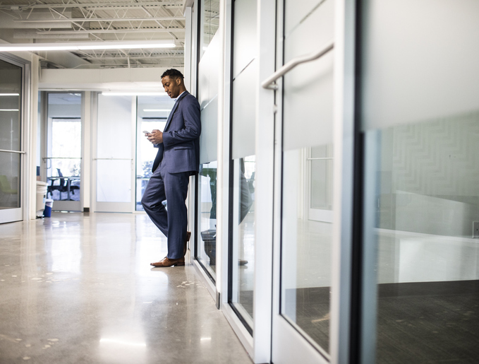 Businessman checking mobile device in modern business office