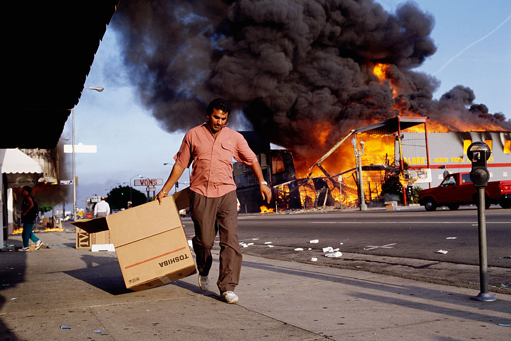 Man Walking Past Burning Building