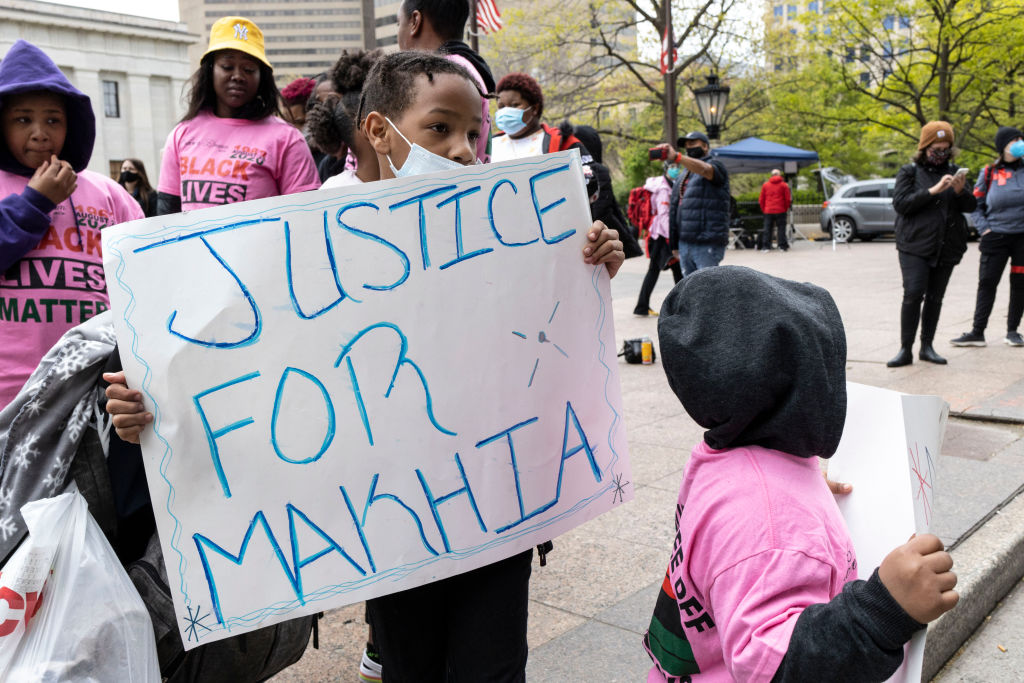 A child holds a placards that says Justice for MaKhia...