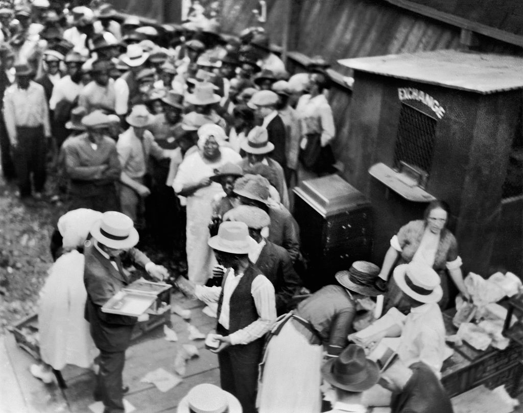 Group of African Americans, some standing in line next to Exchange Booth, during Race Riots, Tulsa, Oklahoma, USA, Alvin C. Krupnick Co. June 1921