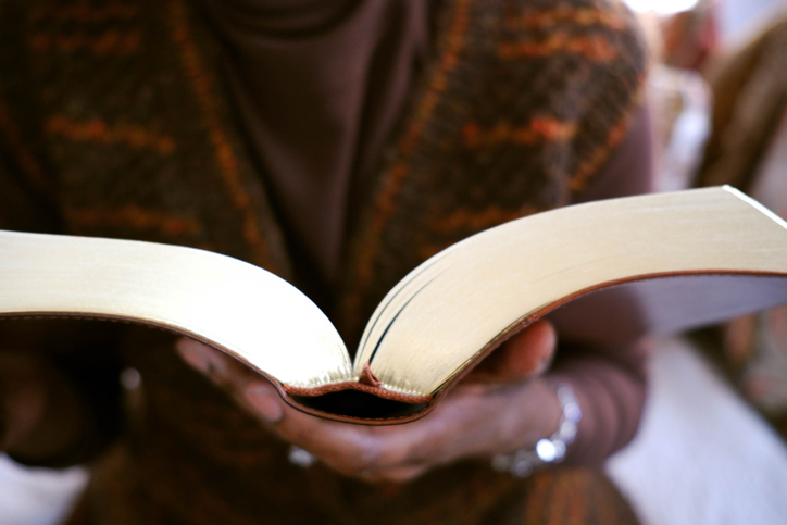 Woman Holds Gilded-Edge Book