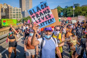 A Black Trans Lives Matter sign held by a participant at the...