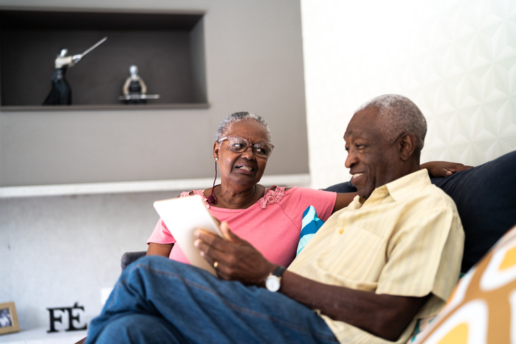 Senior couple using digital tablet at home