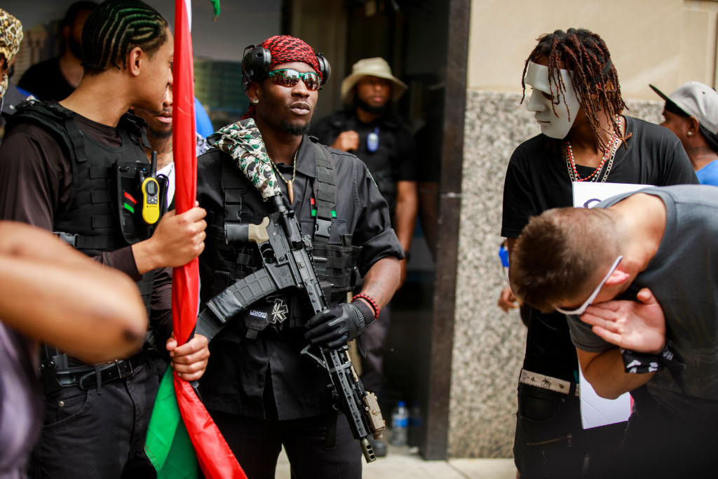 Armed members of the New Black Panthers protest against the...