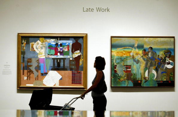 A visitor with a baby views the exhibit