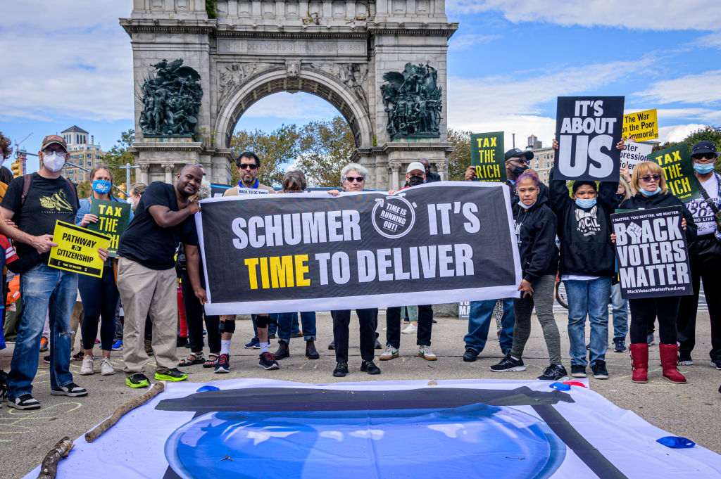 Participants seen holding a banner at the protest. Fair...