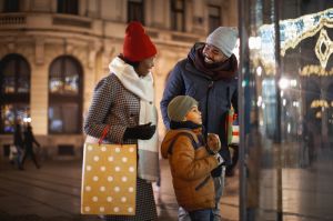 Happy black family Christmas window shopping