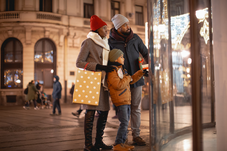 Happy black family Christmas window shopping