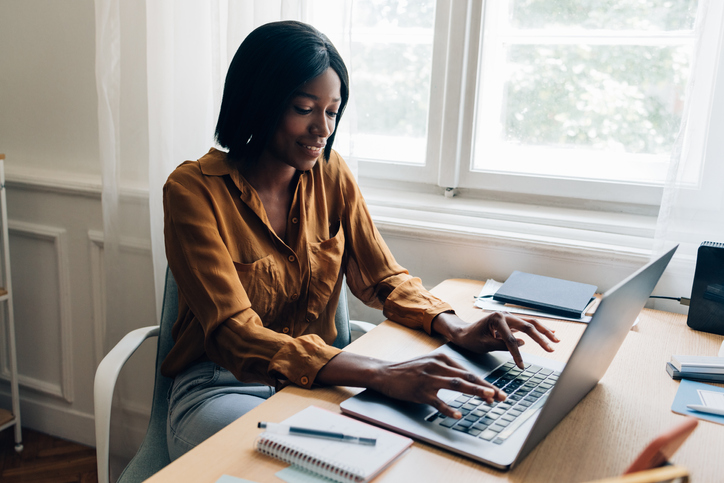Happy Business Woman Working from Home on Laptop Computer