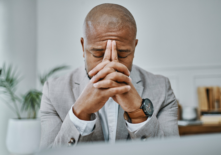 Shot of a mature businessman looking stressed while working in a modern office