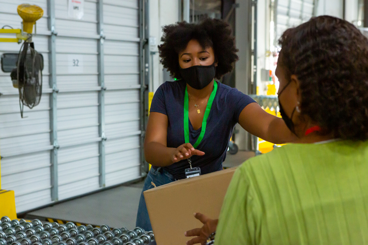 Two Masked Women Loading Truck at Warehouse Loading Dock
