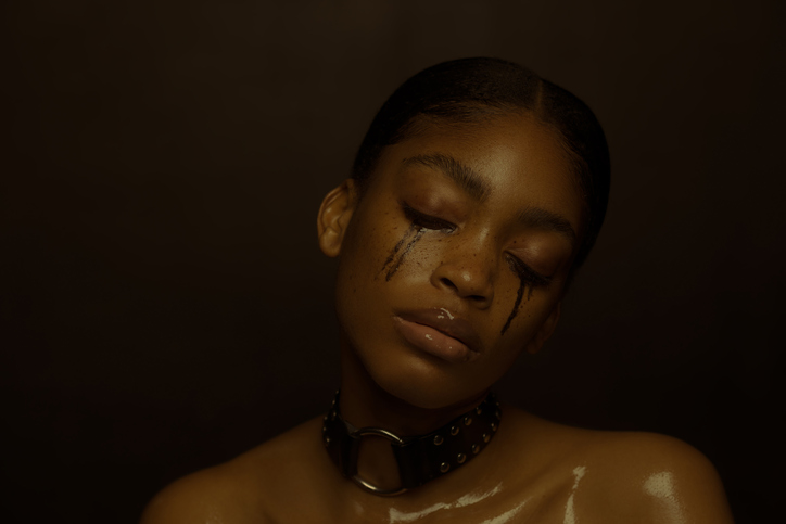 young beautiful woman with black messed make-up crying - stock photo