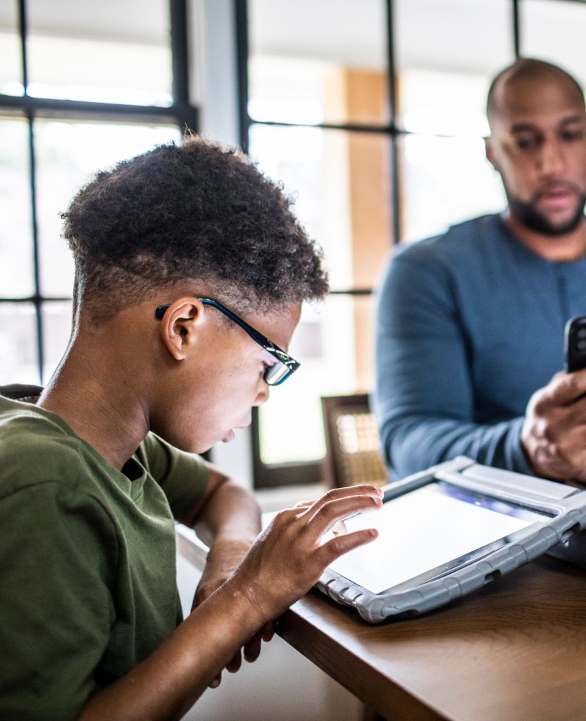 Tween boy using digital tablet in residential kitchen