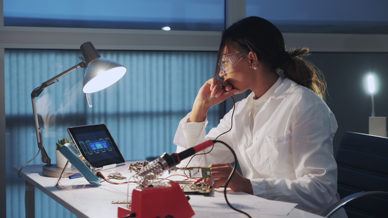 Young Woman Using Mobile Phone While Sitting On Table
