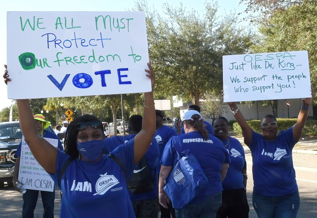 People march with placards in support of voting rights...