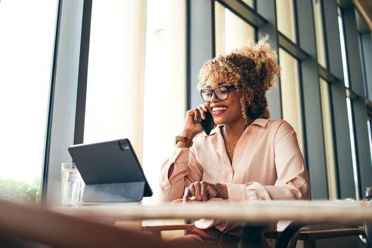Happy Businesswoman Talking On A Mobile Phone In The Cafe