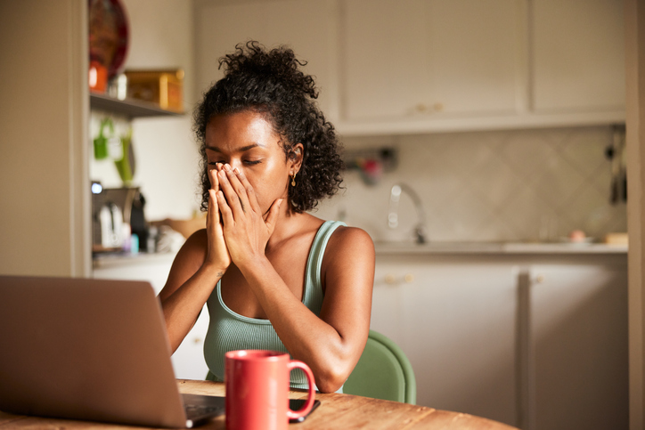 A tired student works with a laptop.