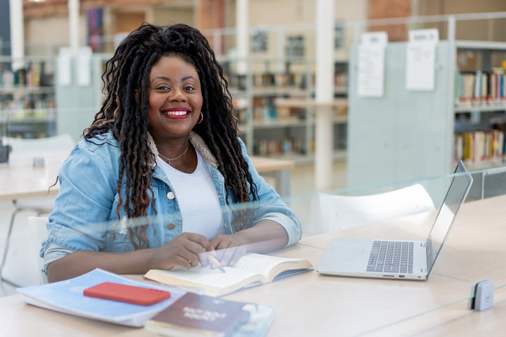 An adult woman studying in the library