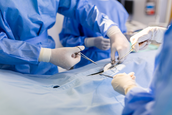 Group of surgeons doing surgery in hospital operating theater. Medical team doing critical operation. Group of surgeons in operating room with surgery equipment. Modern medical background